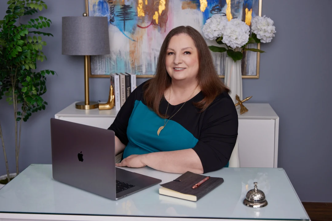 Cassie Lincoln at her desk with laptop and notebook